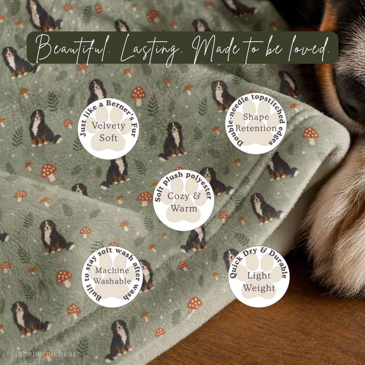 A close-up of the Woodland Mushroom Trail blanket's plush fabric texture, with a Bernese Mountain Dog's snout visible in the corner. A gold banner reads "Beautiful. Lasting. Made to be loved." Five paw-print icons list features: Velvety Soft (just like a Berner's fur), Shape Retention (double-needle topstitched edges), Cozy & Warm (soft plush polyester), Machine Washable (built to stay soft after wash), and Light Weight (quick dry & durable).