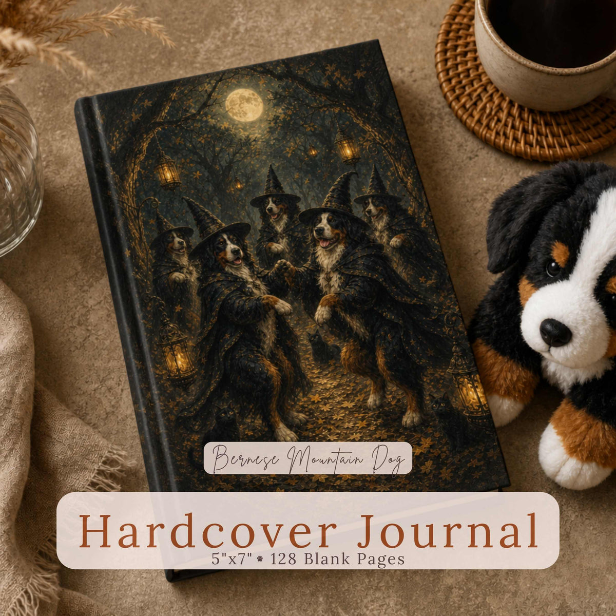 A Bernese Mountain Dog plush toy sits beside a hardcover journal featuring Bernese Mountain Dogs dressed as witches dancing in a moonlit forest with glowing lanterns, with a circular close-up inset of the pattern, on a warm taupe surface with dried pampas grass and a coffee cup. Text reads "Bernese Mountain Dog Hardcover Journal, 5"x7" • 128 Blank Pages."